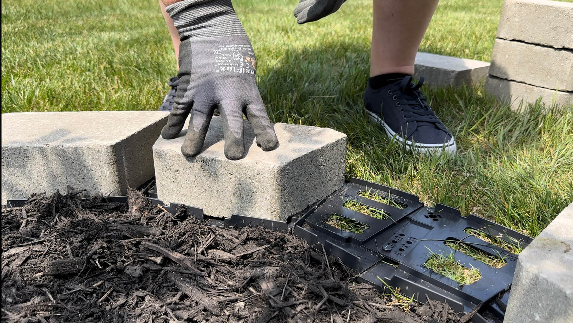 Placing a paver brick onto the PaverTrax track system